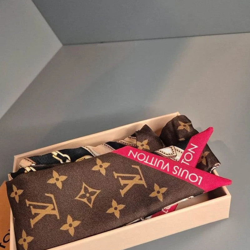 Bandeau en soie Louis Vuitton plié dans sa boîte – motif Monogram et extrémité rose avec logo