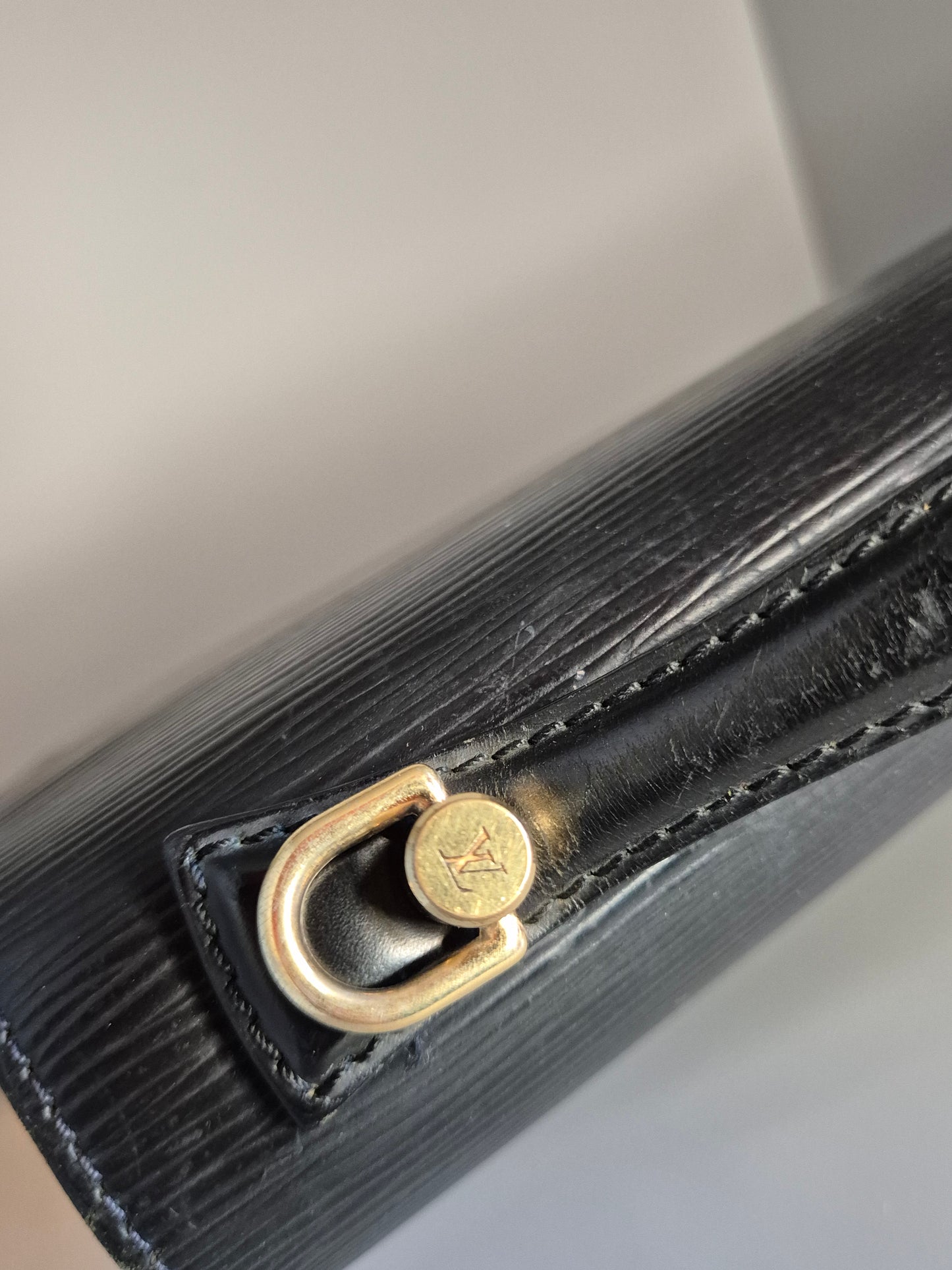 Zoom sur attache bandoulière dorée – Monceau Louis Vuitton