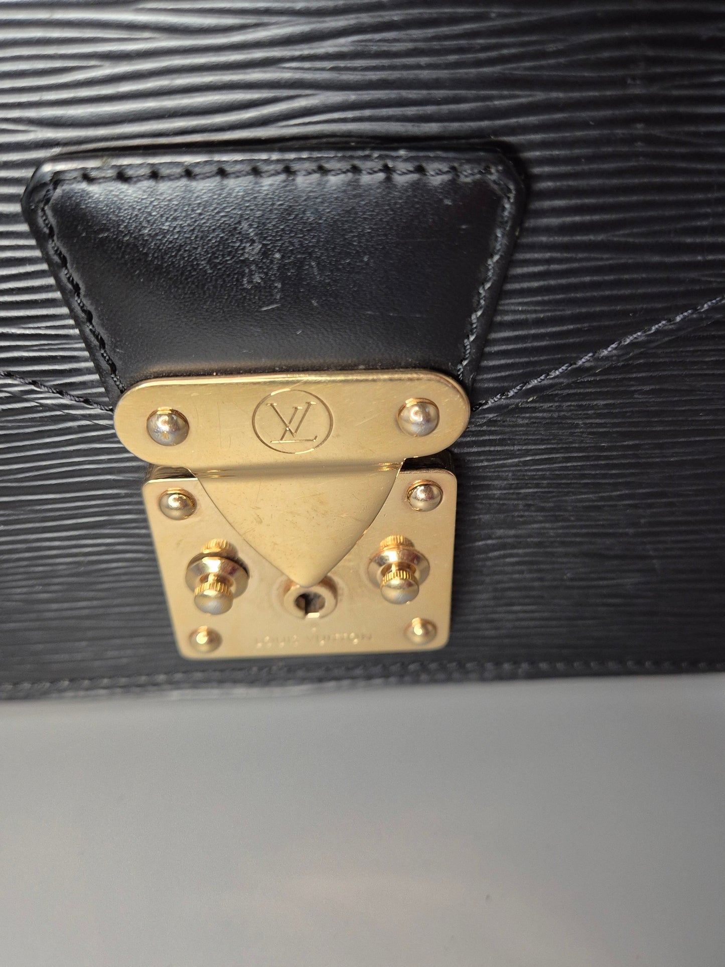 Zoom sur le fermoir doré gravé Louis Vuitton du Monceau