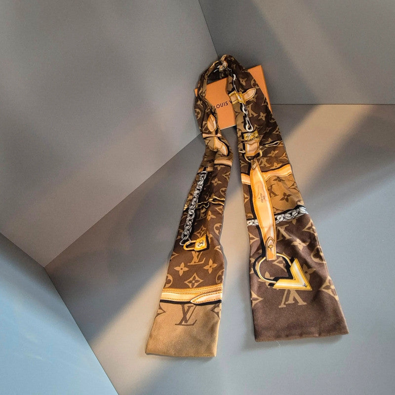 Motifs dorés sur bandeau marron – chaîne, cadenas et logo Louis Vuitton