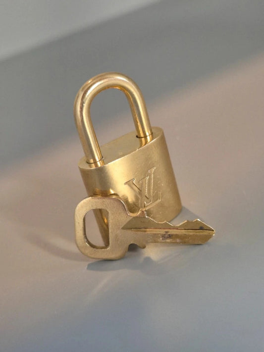 Cadenas Louis Vuitton doré avec clé assortie – vue principale en lumière douce