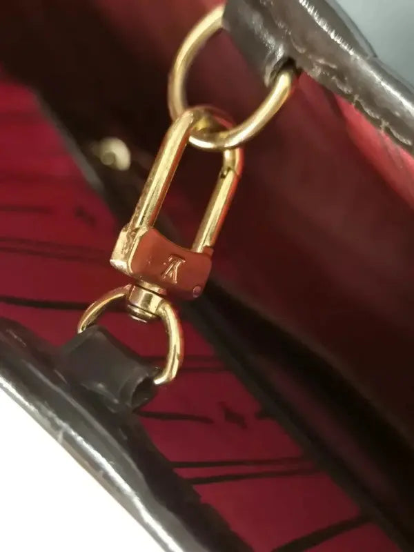 Crochet intérieur du sac Louis Vuitton Neverfull MM, permettant la fermeture du sac, en laiton doré.