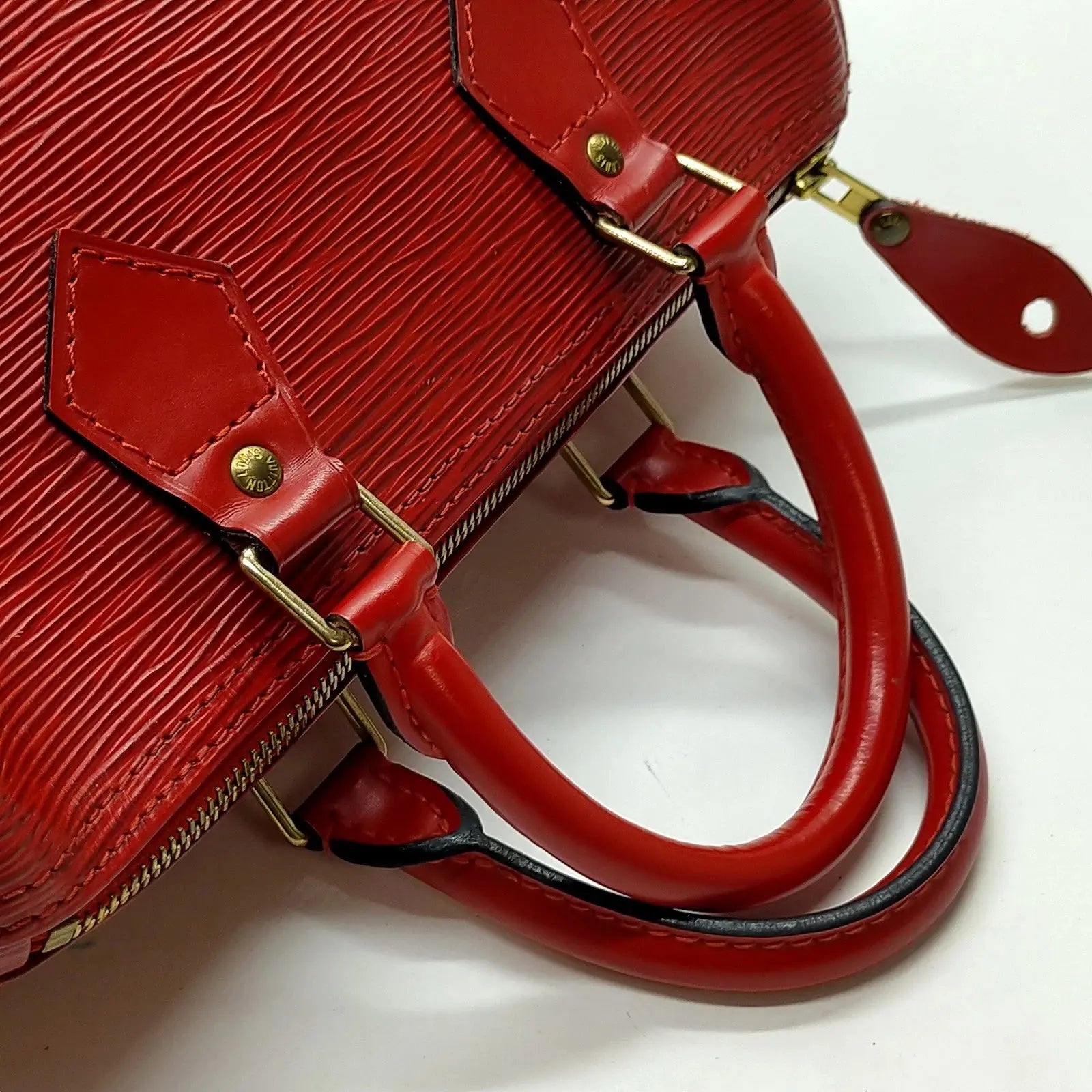 Zoom sur les anses et la fermeture éclair dorée du Speedy 12 Louis Vuitton – cuir Épi rouge